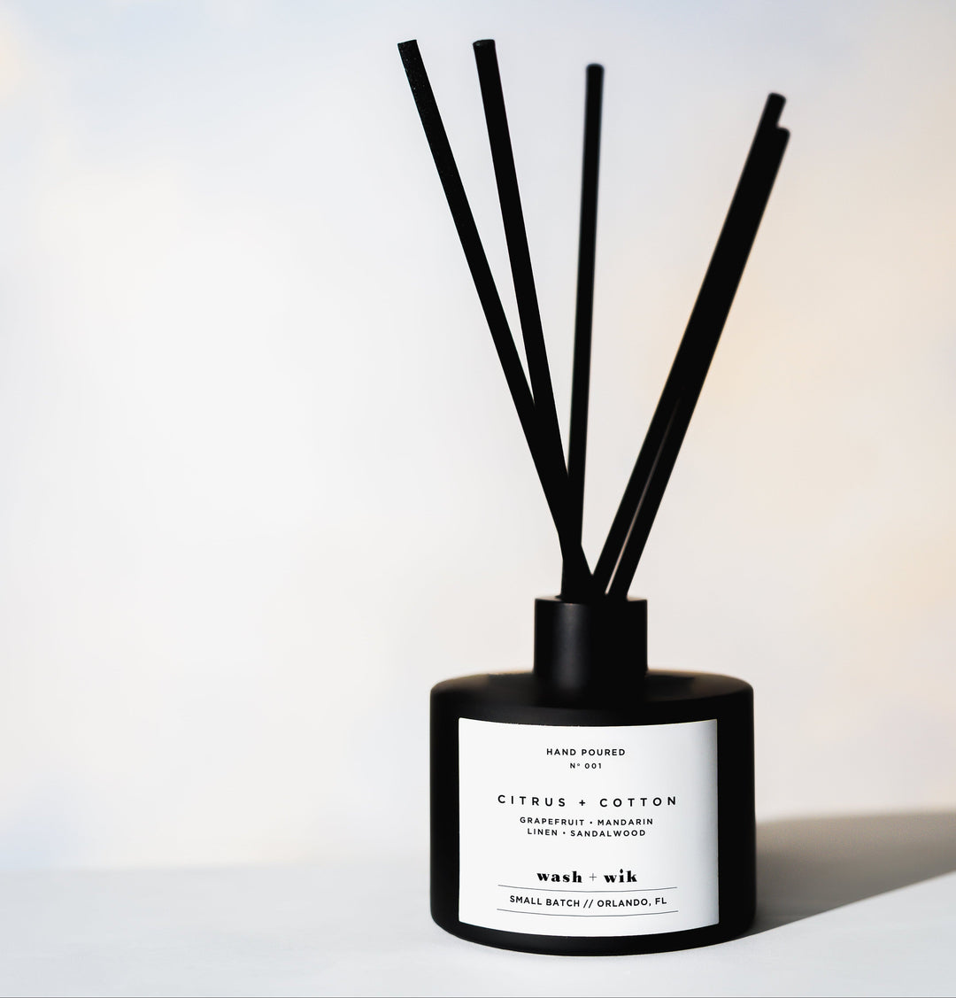 Black reed diffuser in front of white background