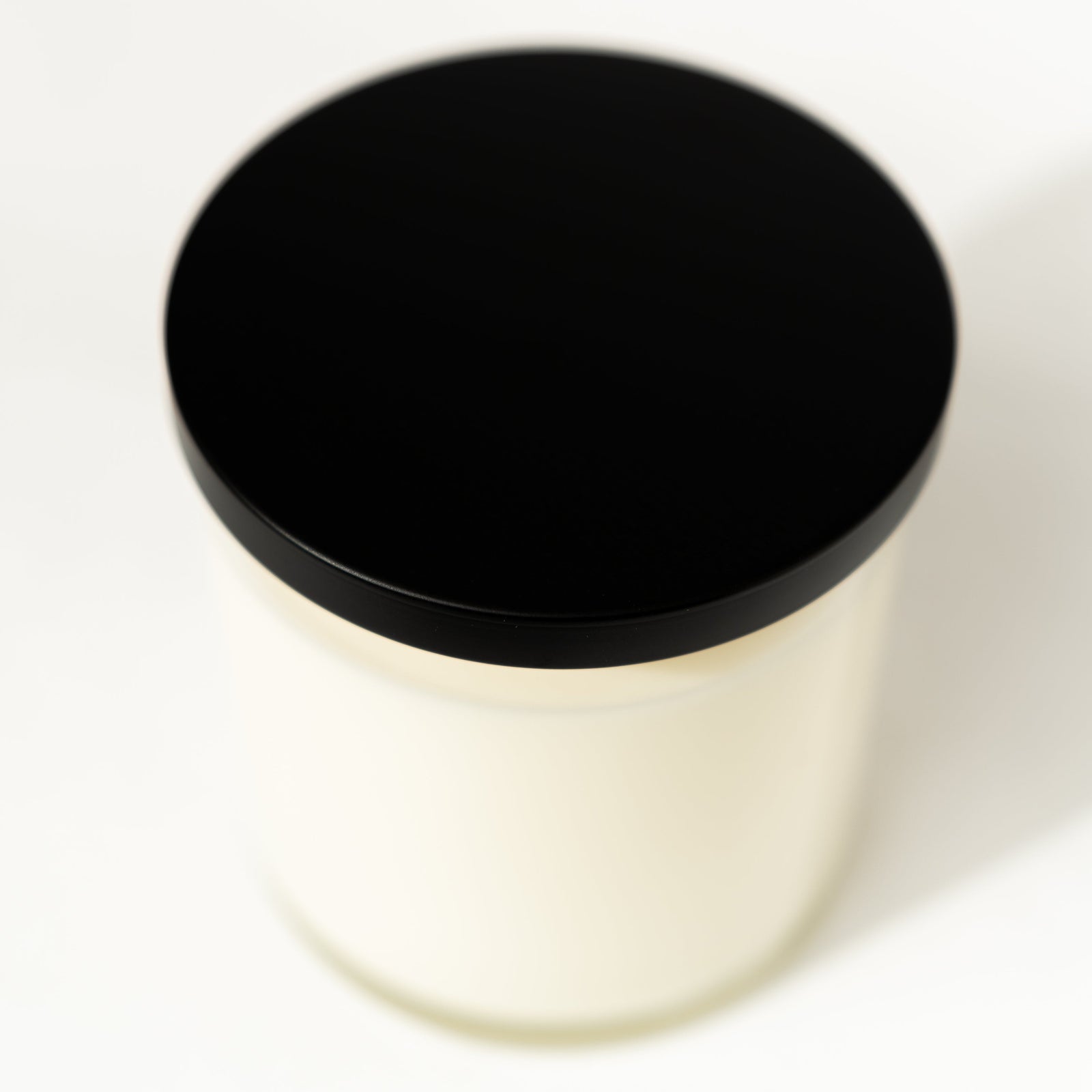 White container with a black lid on a white background