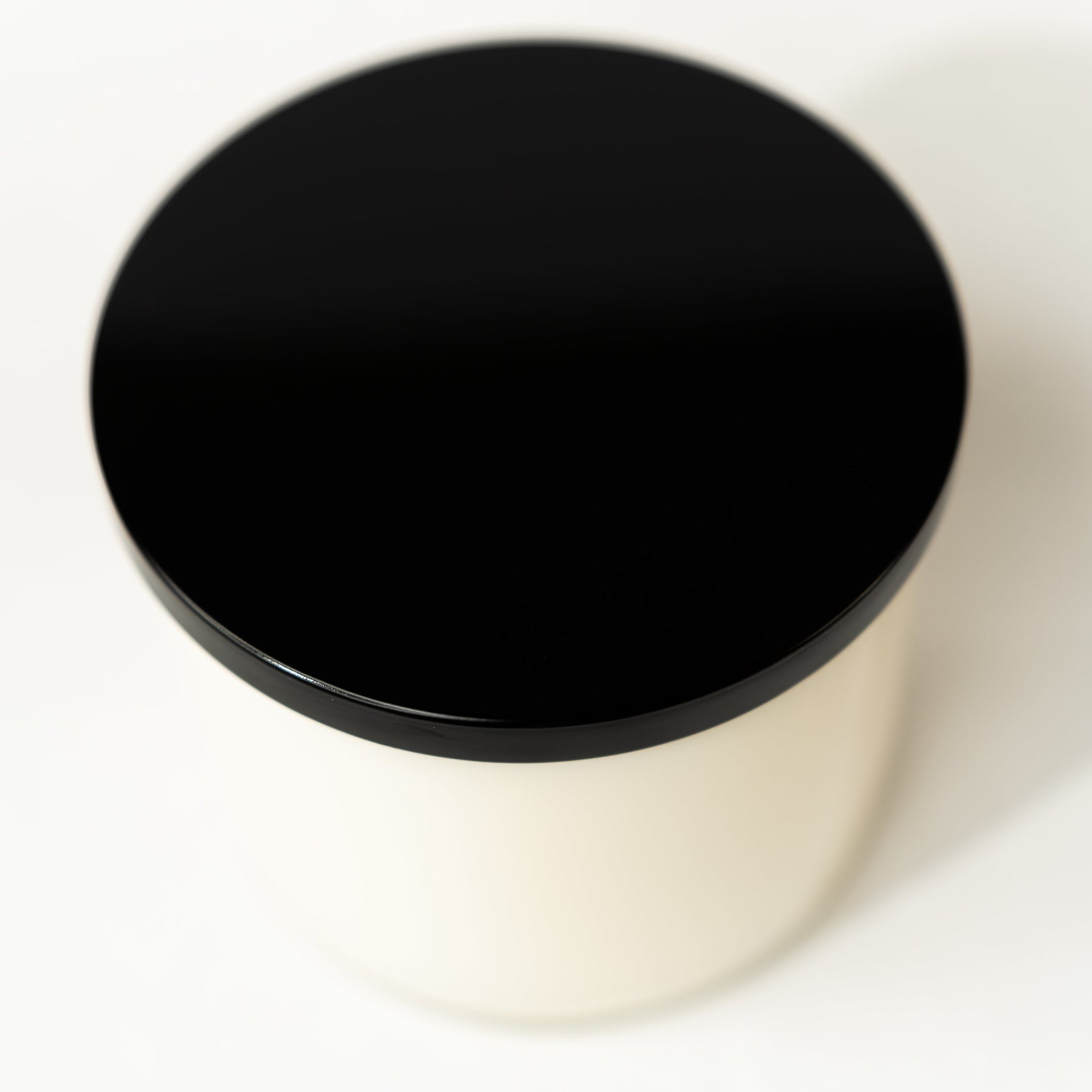 Black lid on a white container with a white background