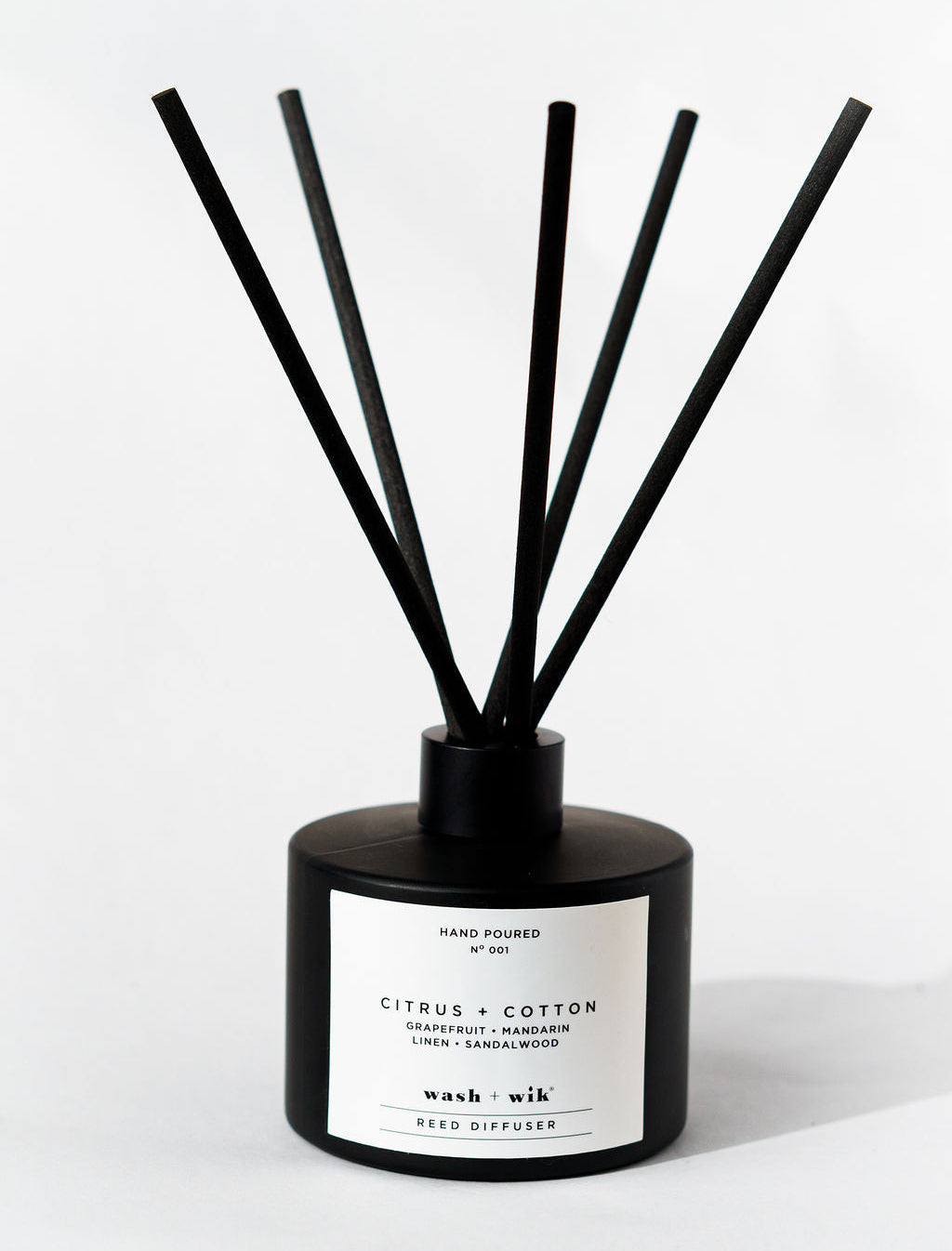 Black diffuser with sticks on a white background