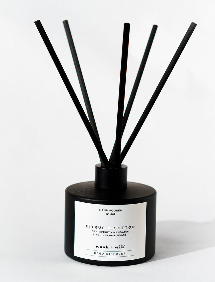 Black diffuser with sticks on a white background