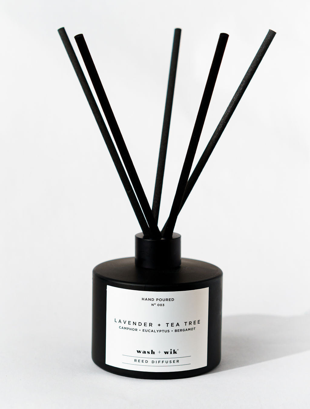 Black diffuser with sticks on a white background