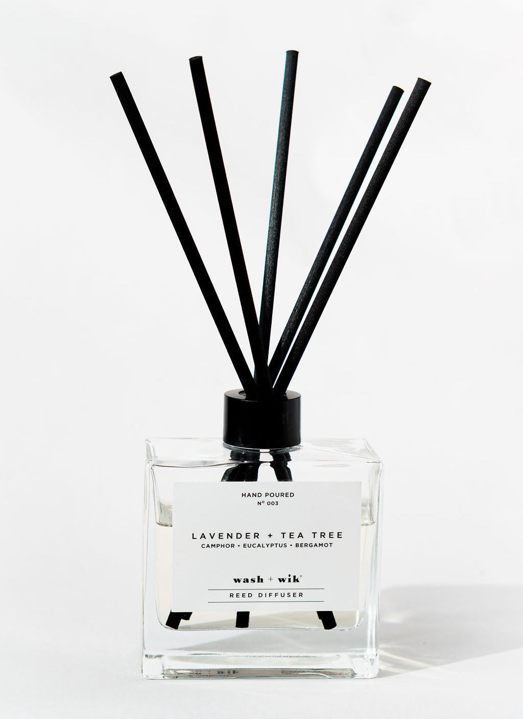 Reed diffuser with black sticks on a white background