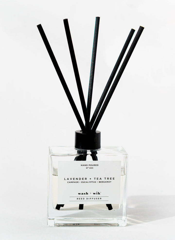 Reed diffuser with black sticks on a white background