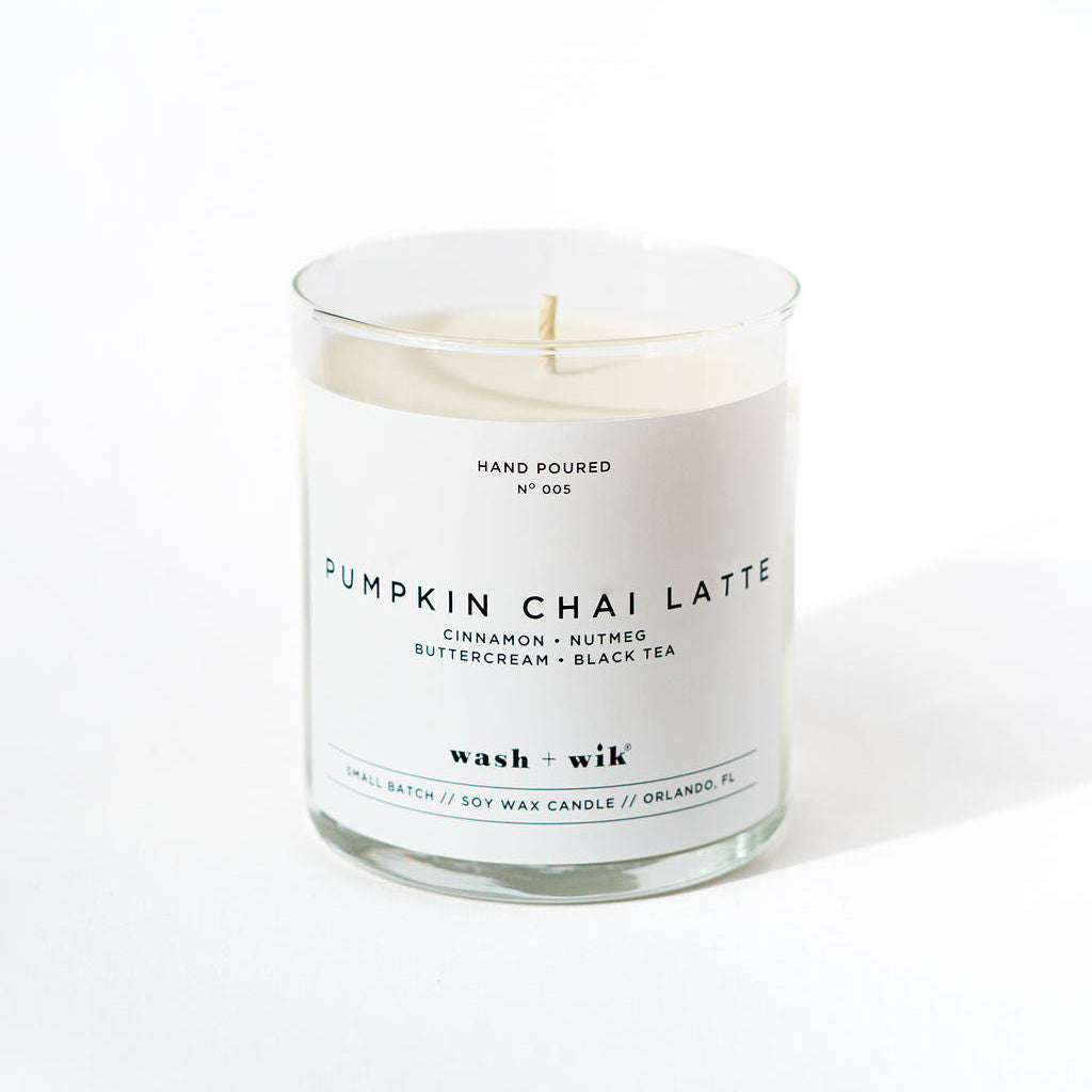 Candle labeled 'Pumpkin Chai Latte' with a white label on a white background
