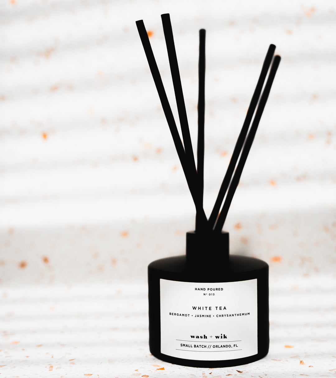 Black diffuser with sticks on a light background