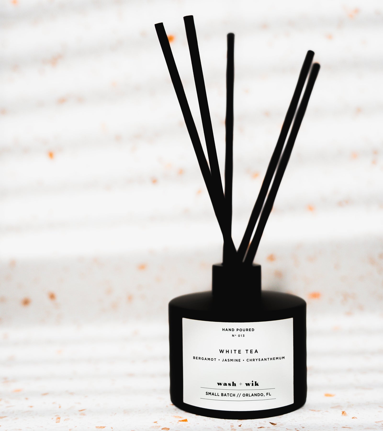 Black diffuser with sticks on a light background