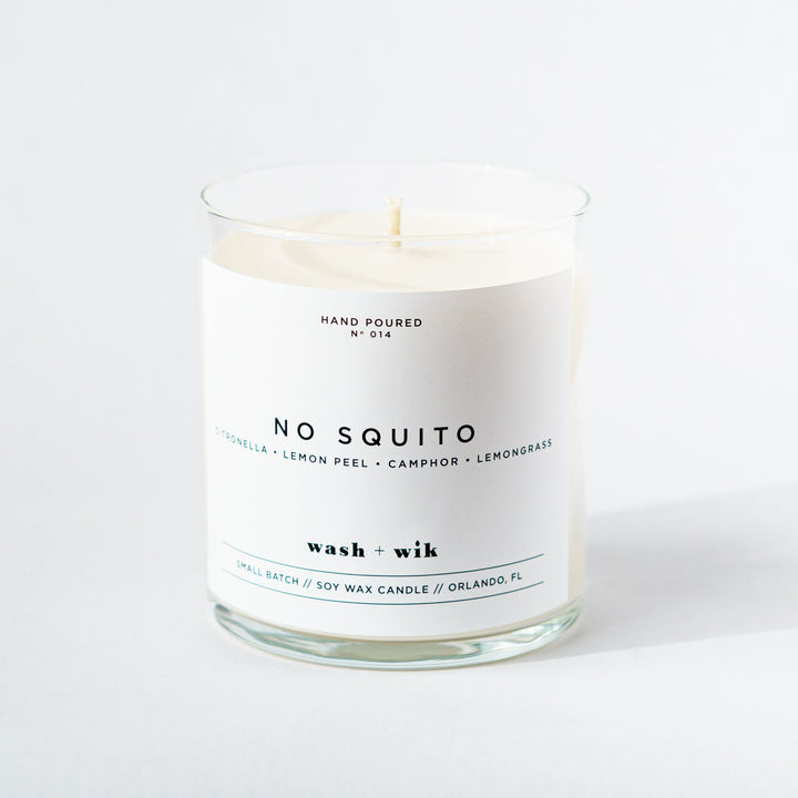 Candle in a glass jar with a white label on a white background