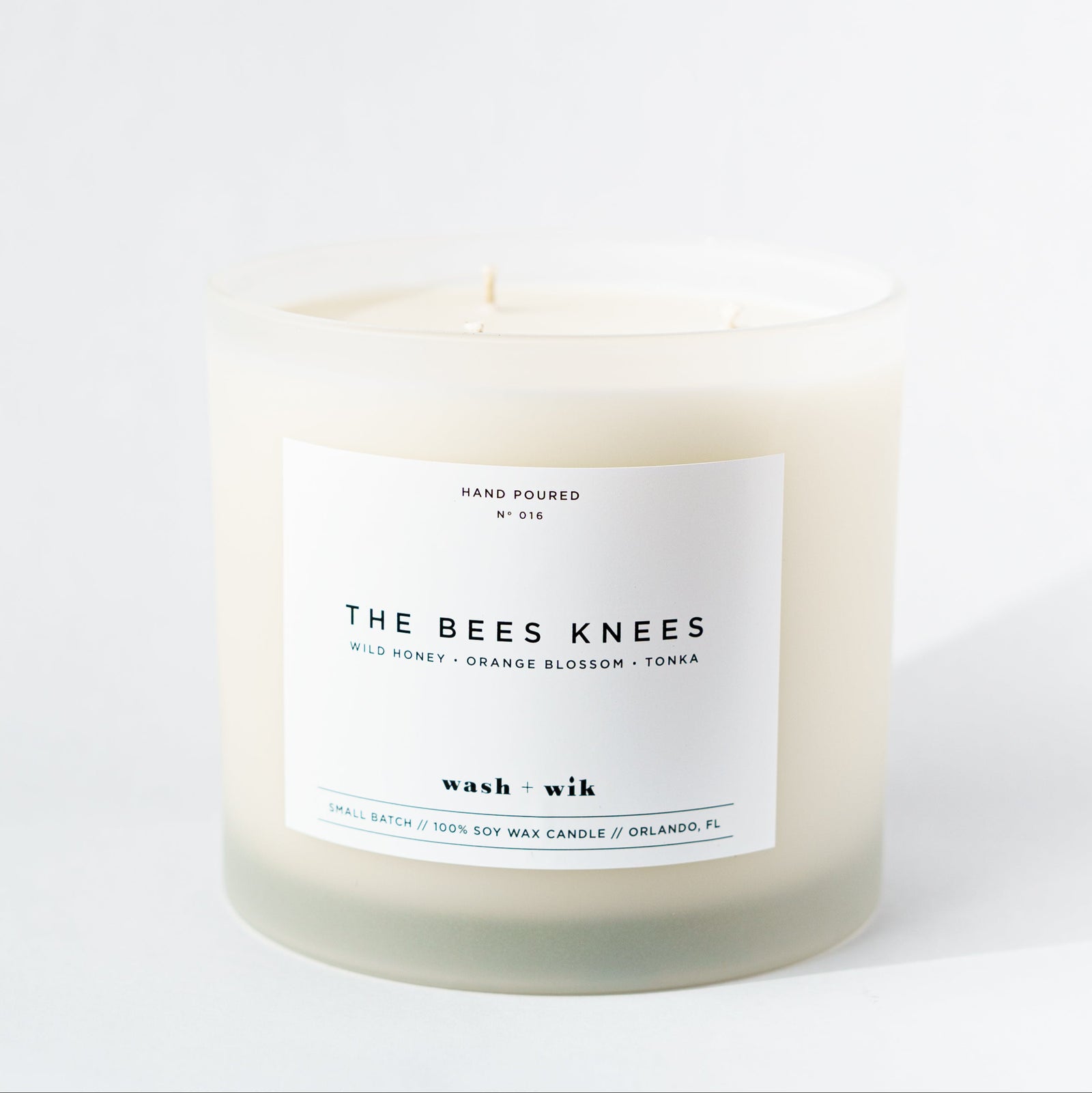 Candle labeled 'The Bees Knees' on a white background