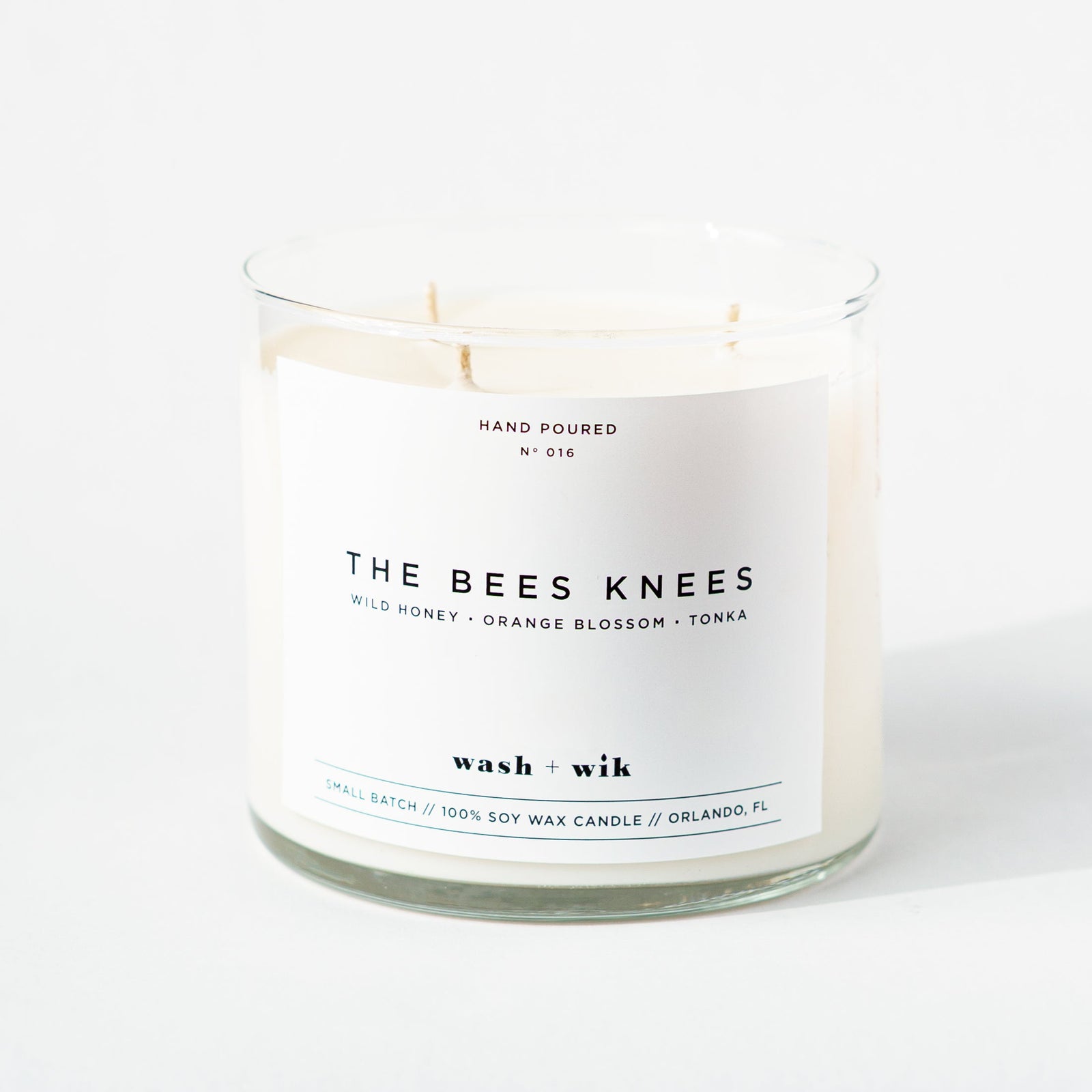 Candle in a glass jar with a label on a white background