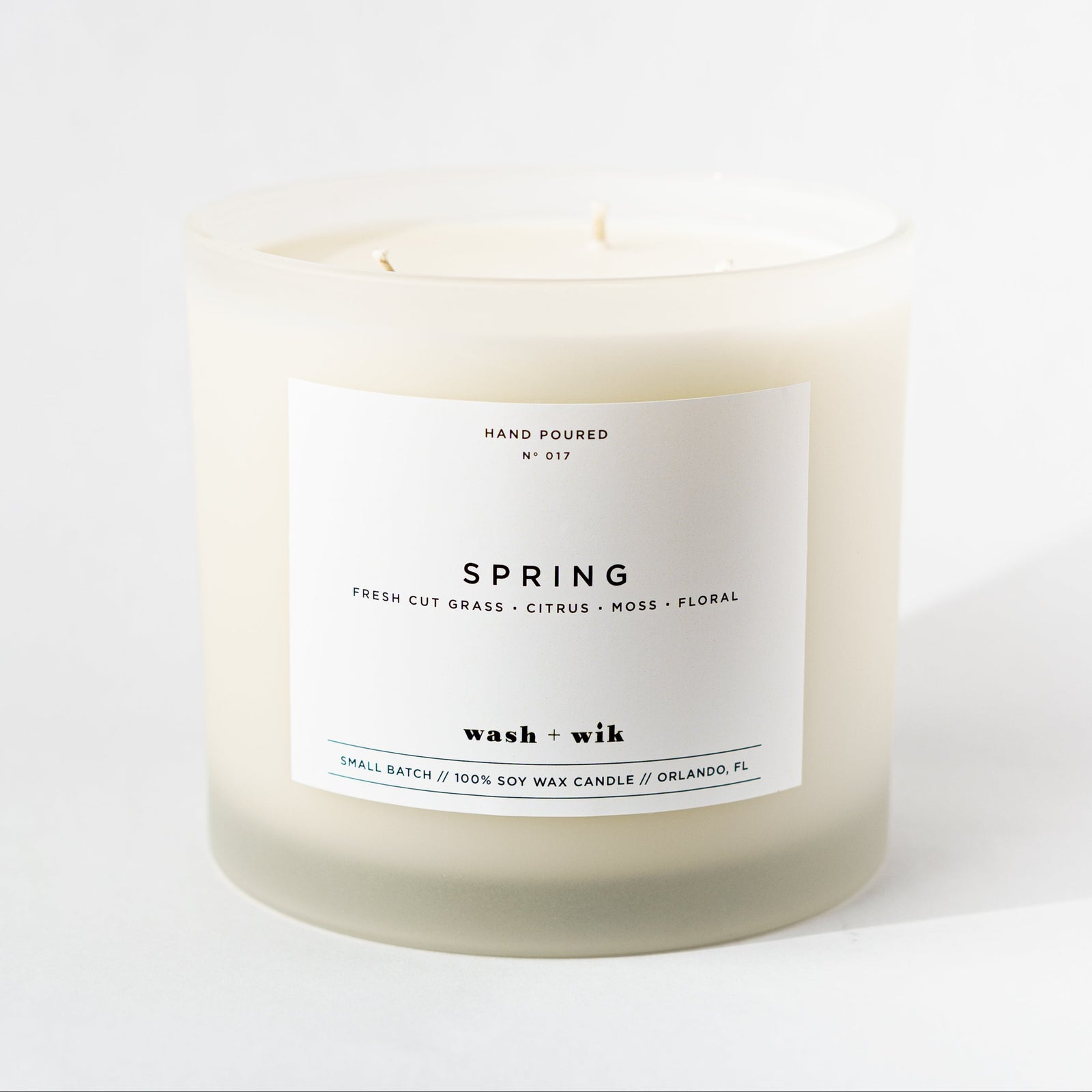 Candle labeled 'Spring' with a white label on a white background