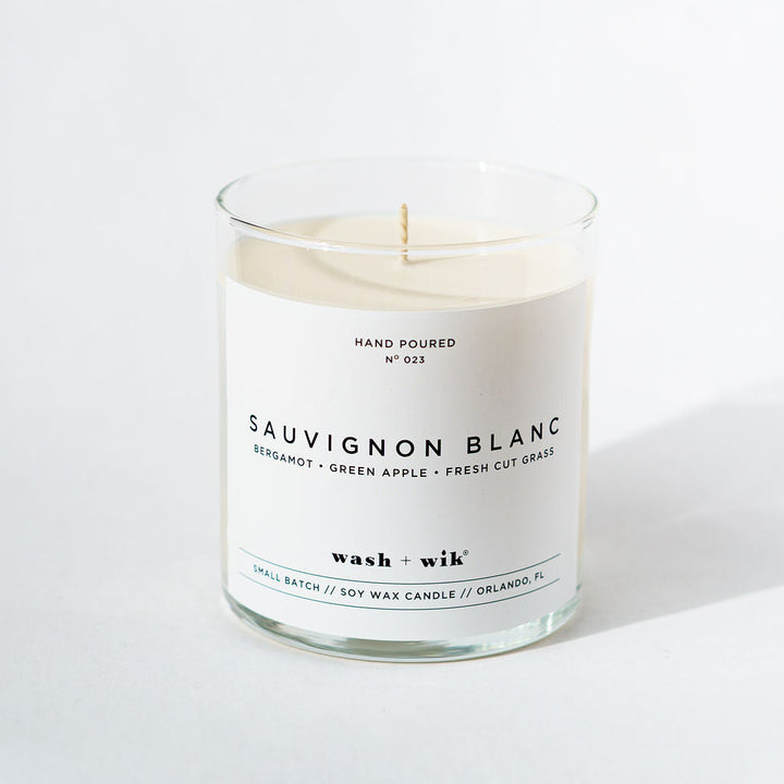 Candle in a glass jar with a white label on a white background