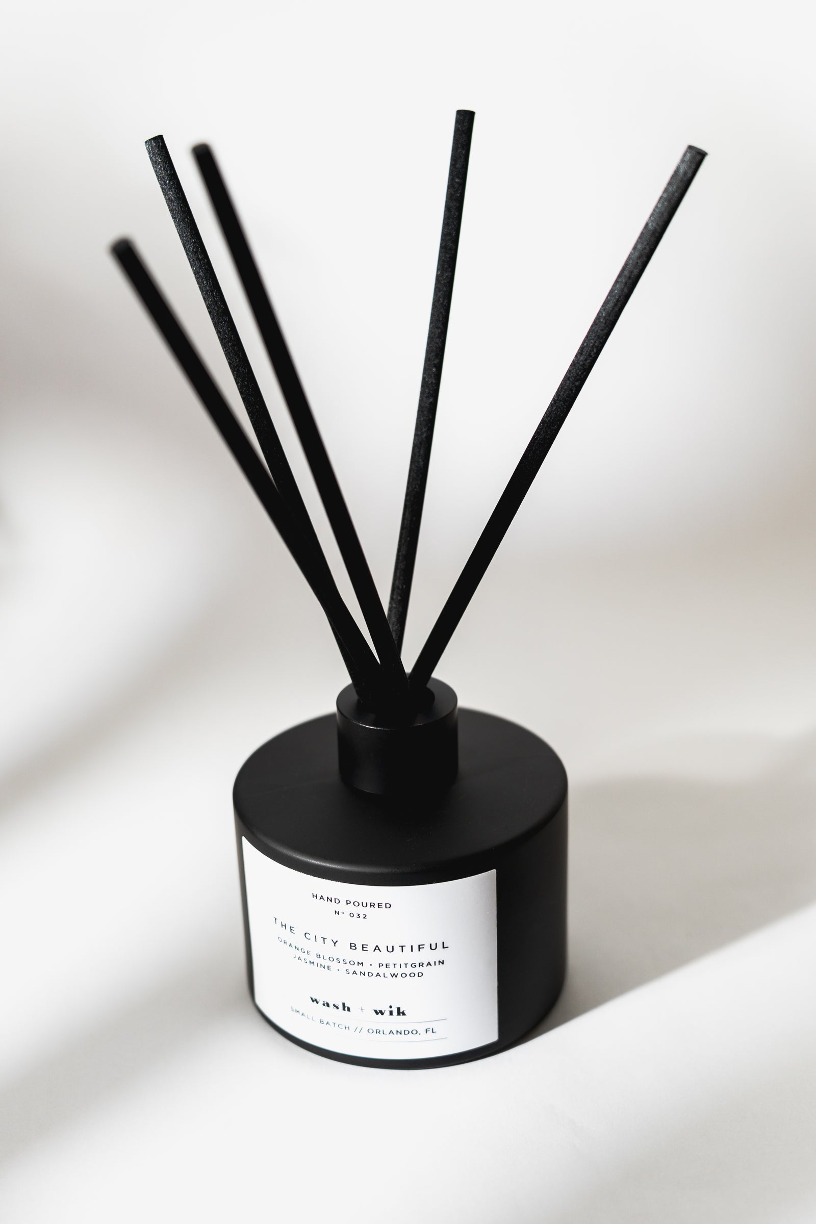 Black diffuser with sticks on a white background