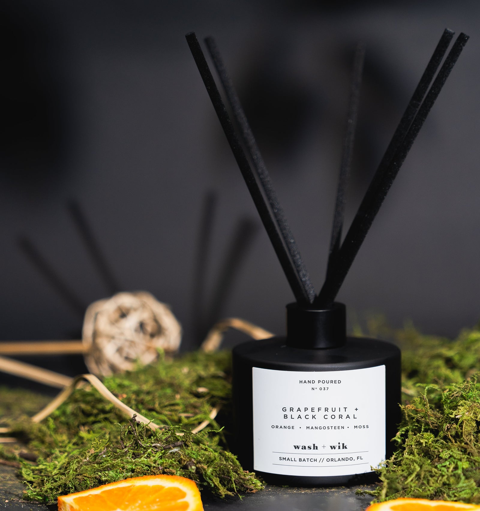 Black diffuser with reeds and decorative elements on a dark background