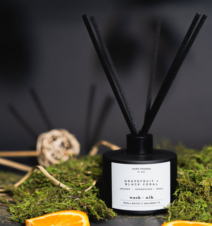 Black diffuser with reeds and decorative elements on a dark background