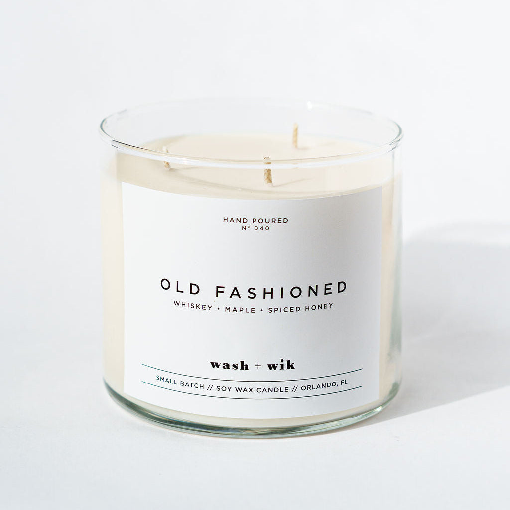Candle in a glass jar with a label on a white background