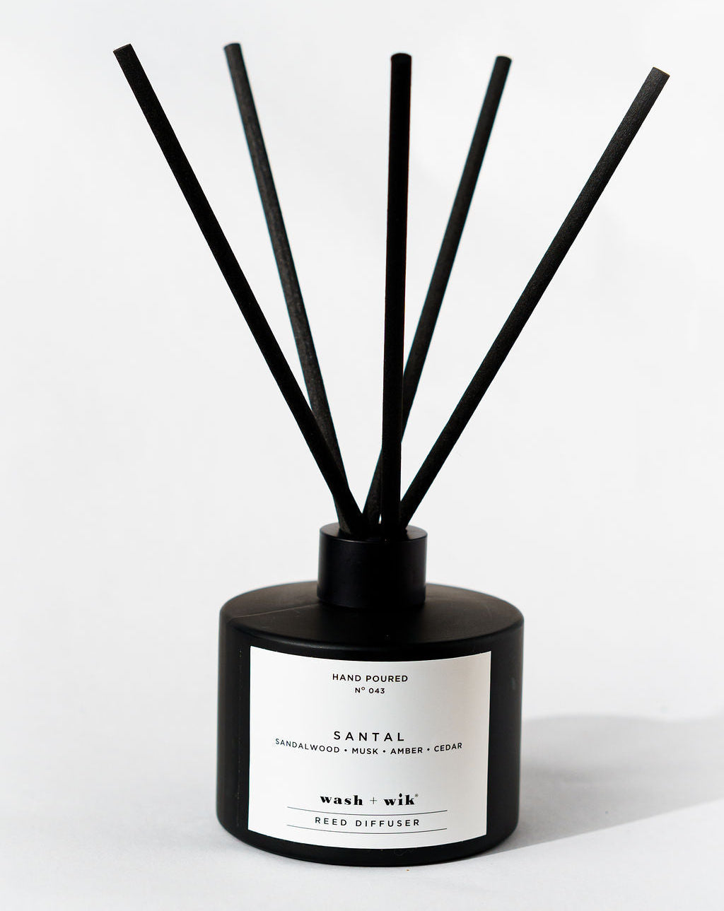 Black diffuser with sticks on a white background