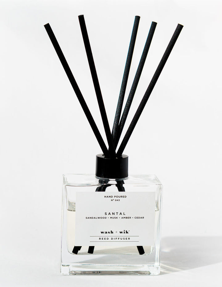 Reed diffuser with black sticks on a white background