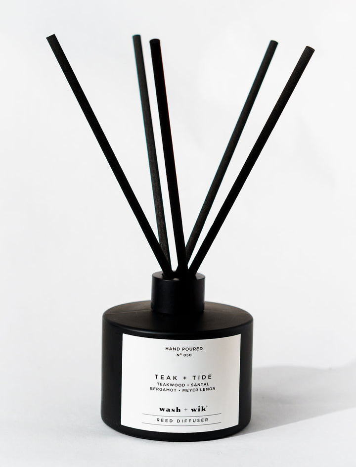 Black and white reed diffuser with sticks on a white background