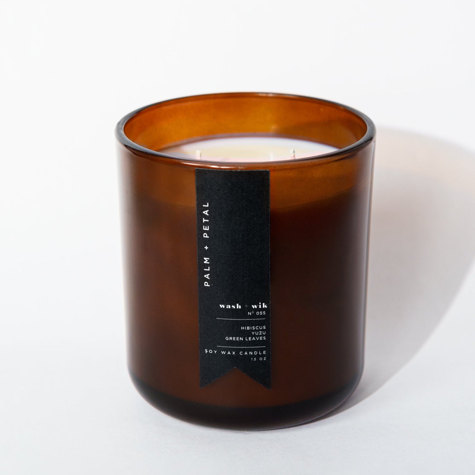 Brown glass candle with a label on a white background