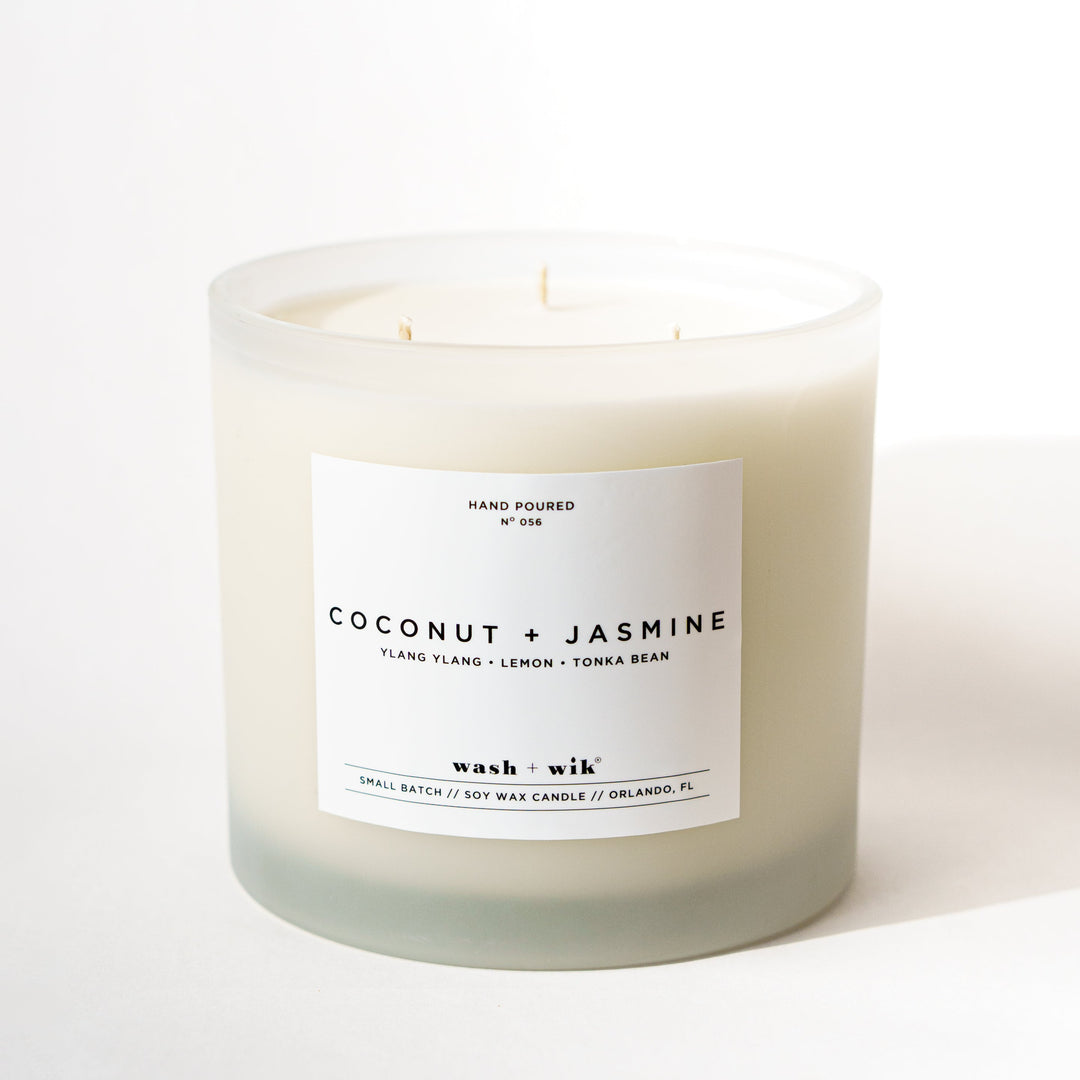 Large frosted candle with a white label and a white background