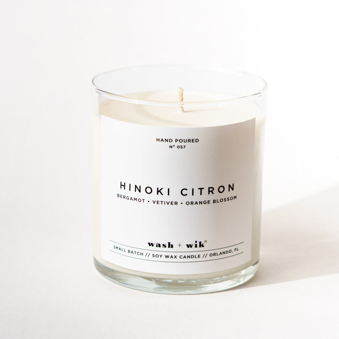 single wick candle with a white label and a white background