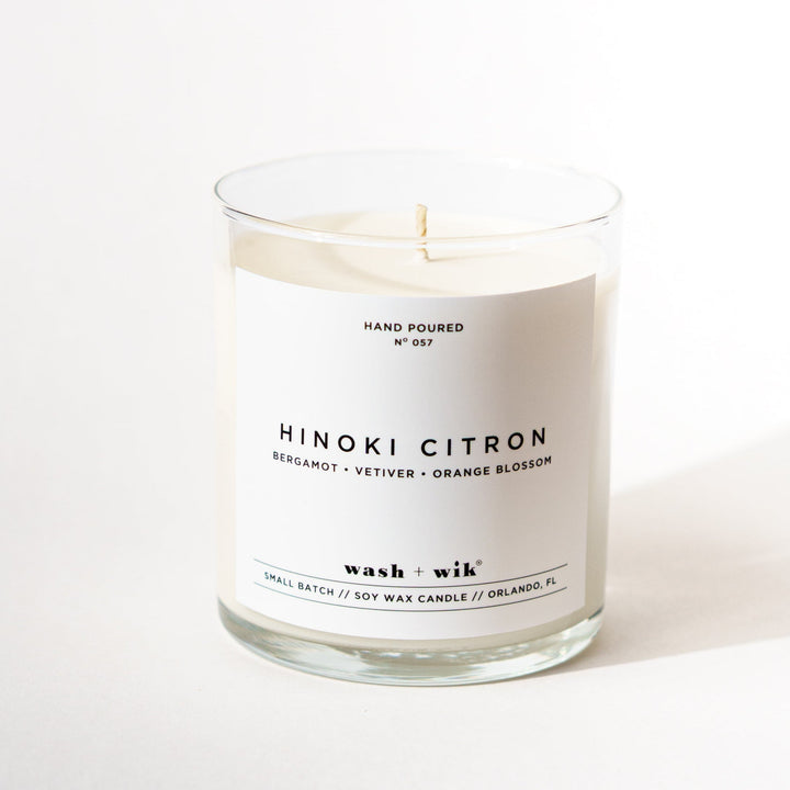 single wick candle with a white label and a white background