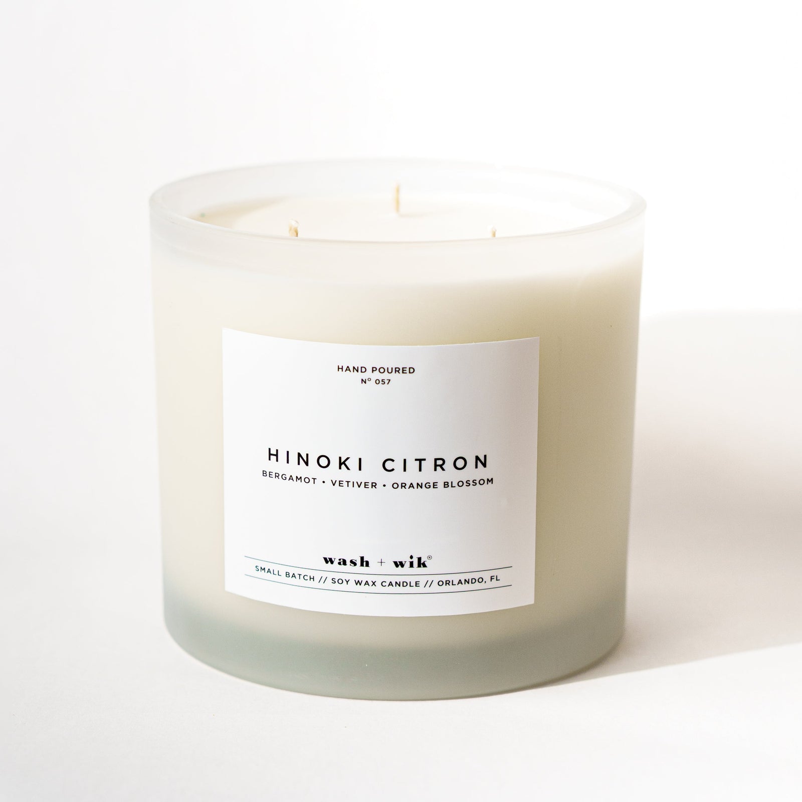 Large frosted candle with a white label and a white background