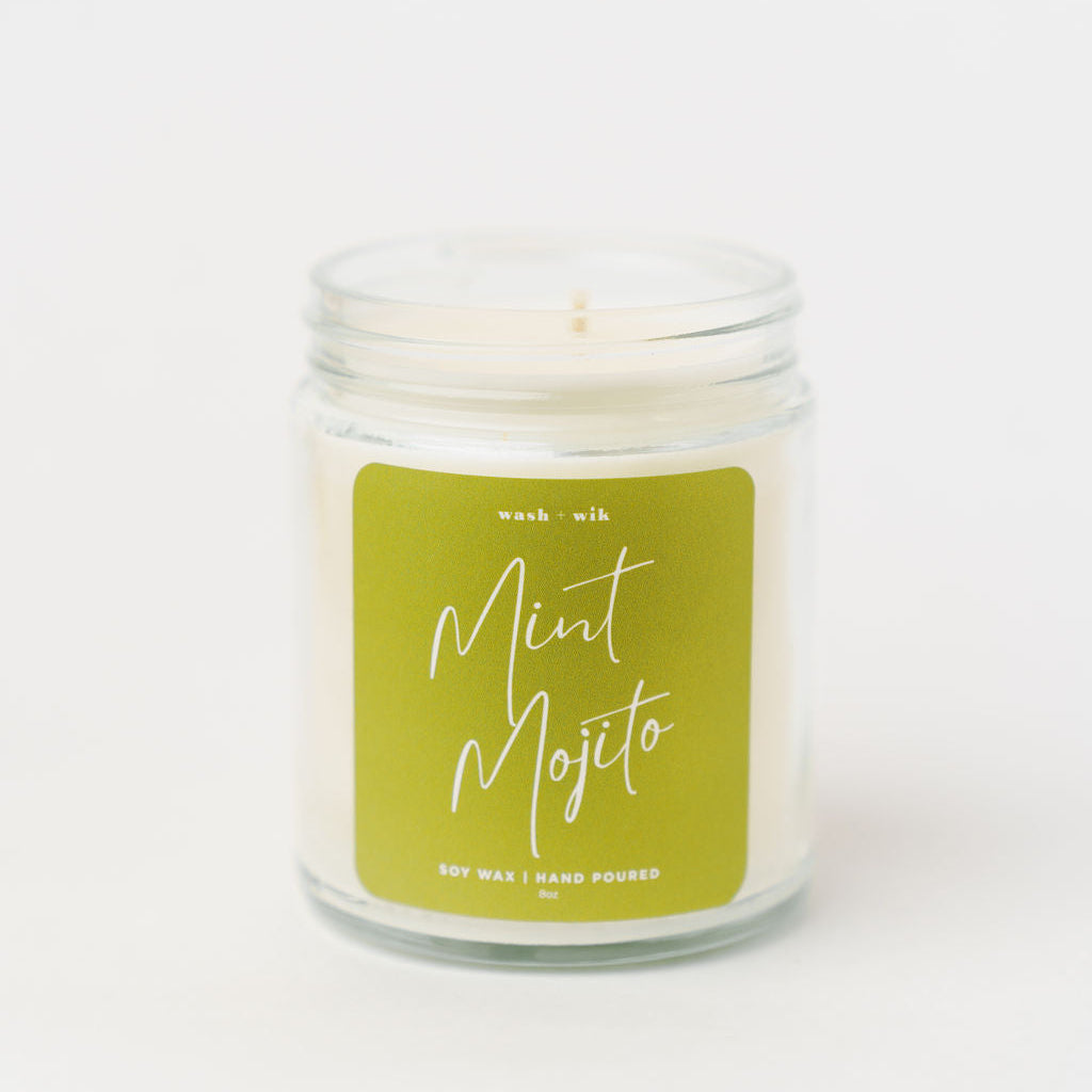 Candle in a glass jar with a green label on a white background