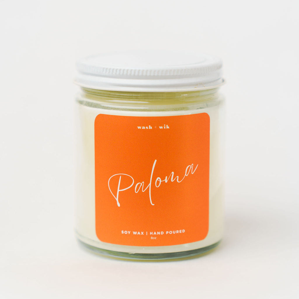 Candle jar with an orange label on a white background