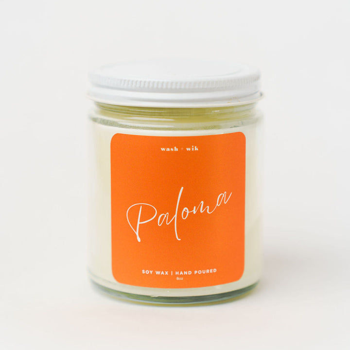 Candle jar with an orange label on a white background