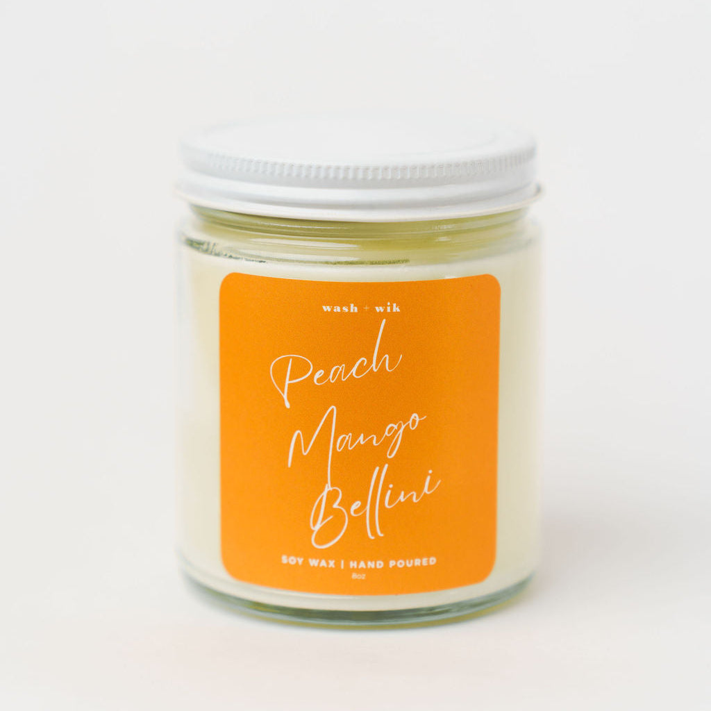 Candle jar with an orange label on a white background