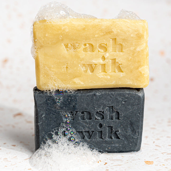 Two bars of soap, one yellow and one black, with &