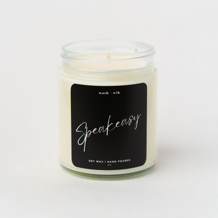 Candle in a glass jar with a black label on a white background