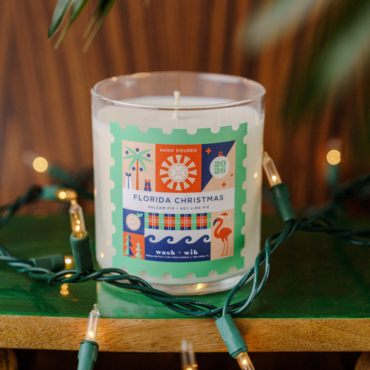 Soy wax candle with a festive background - label is a stamp shape and says Florida Christmas
