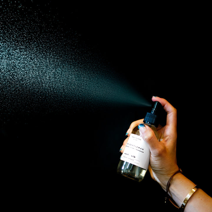 Room Spray spraying in front of black background