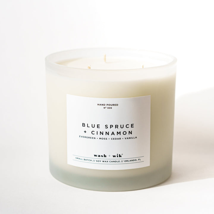 Large hand poured candle in frosted glass and white background