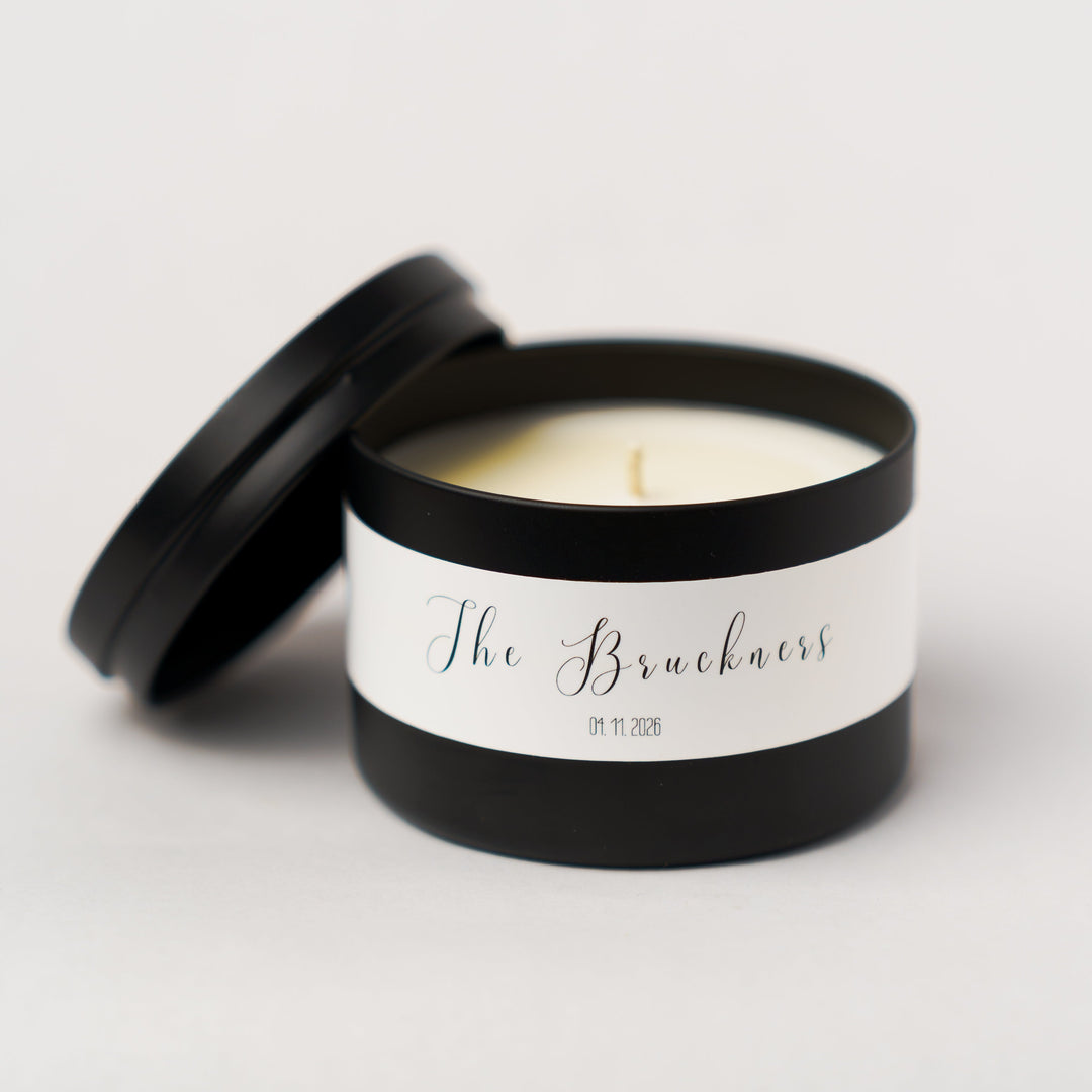 Candle in a tin with a label on a light gray background