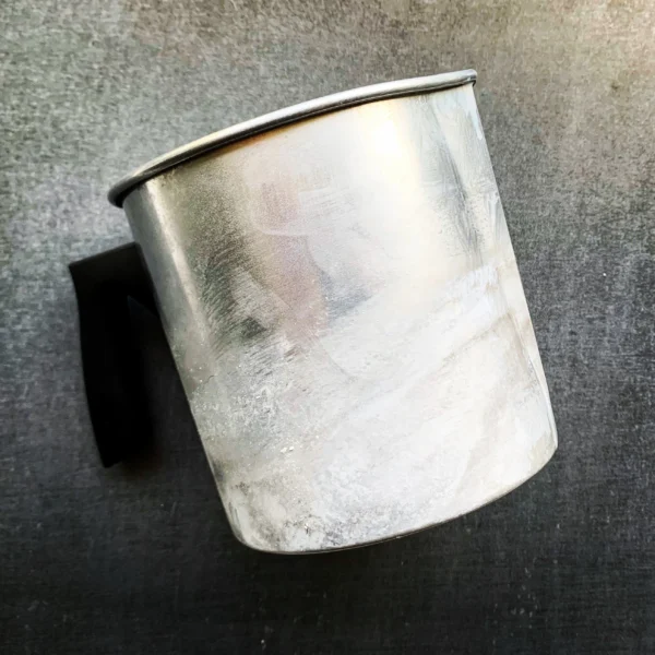 A metal cup with ice inside of it.