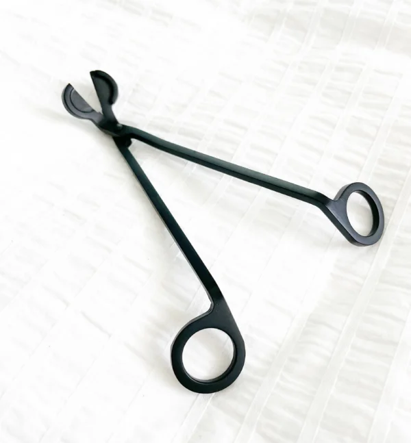 A pair of black scissors sitting on top of a table.