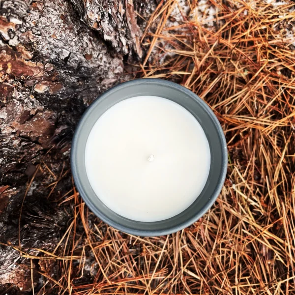 A candle sitting on top of some hay.