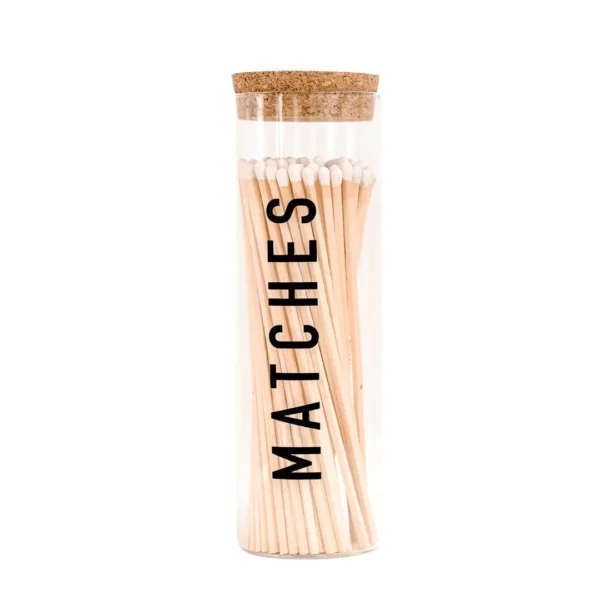 A glass tube with matches on top of it.