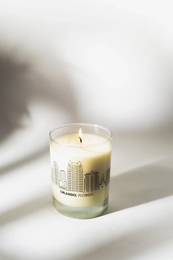 A candle is lit in front of the city skyline.