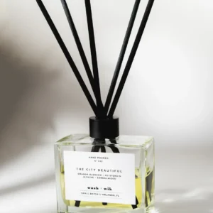 A square bottle of reed diffuser with black sticks.