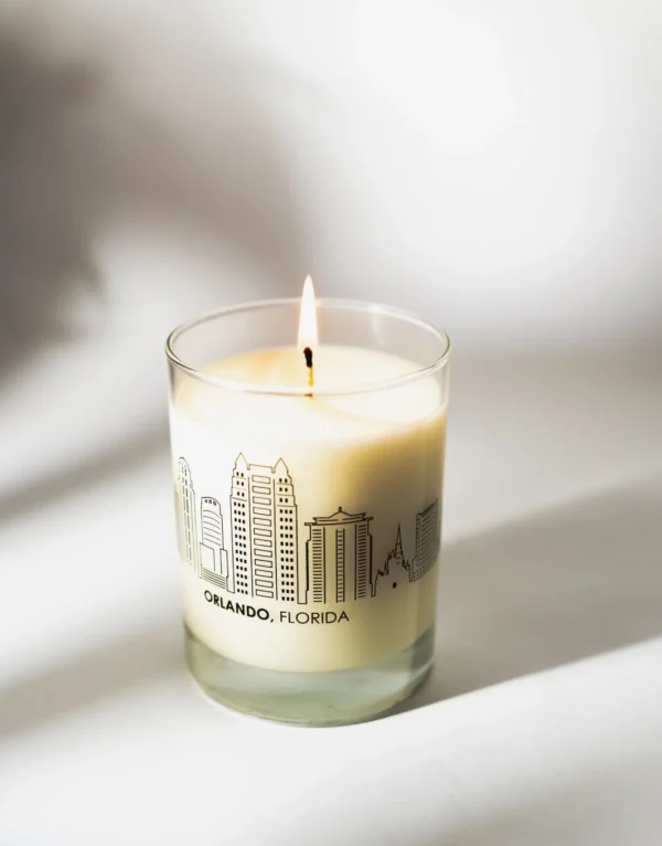 A candle is lit in front of the city skyline.