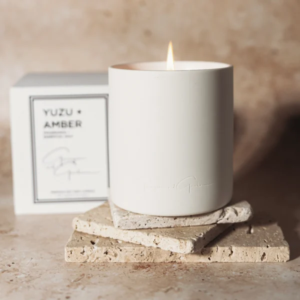 A candle sitting on top of some coasters.