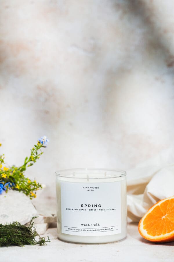 A candle sitting on top of a table next to flowers.