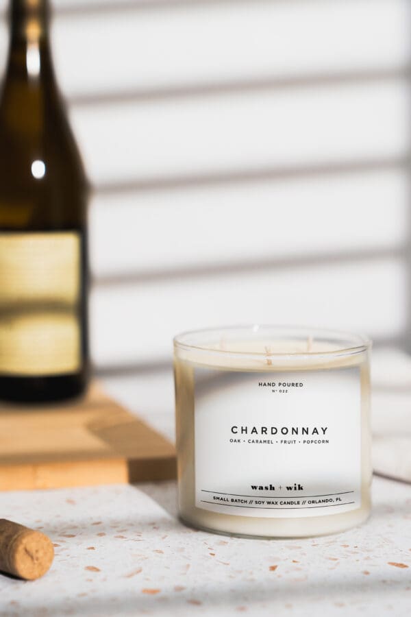 A candle sitting on top of a table next to a bottle.