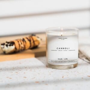 A candle sitting on top of a table next to some food.