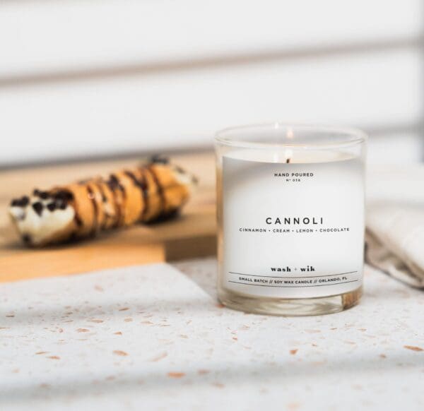 A candle sitting on top of a table next to some food.